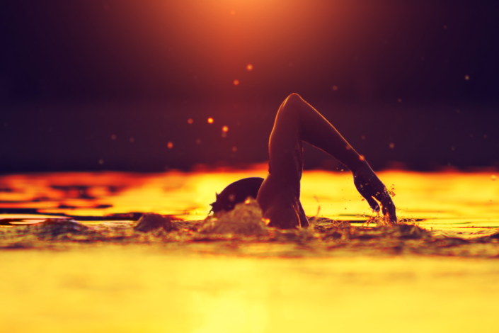 Richtig Kraulschwimmen im Freiwasser im Sonnenuntergang © unknown / AdobeStock